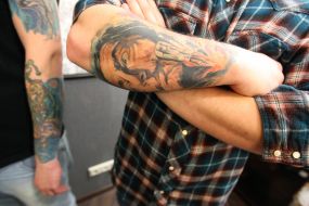 A man shows his tattoo