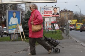 Жінка проходить повз агітаційні передвиборні плакати 