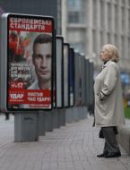 Жінка розглядає агітаційний передвиборчий плакат партії "УДАР"