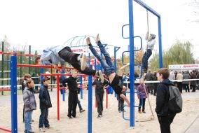 Young people perform exercises on crossbar