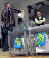 Мужчина бросает бюллетень в урну для голосования