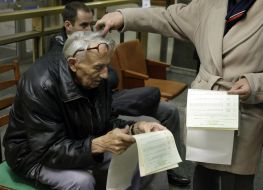 Пожилой мужчина держит бюллетень для голосования
