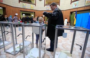 Избиратели бросают бюллетени для голосования в урну