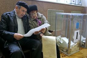 Літні люди розглядають бюлетені