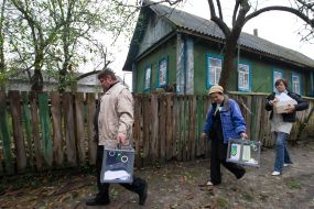 Члены избирательной комиссии несут переносные урны