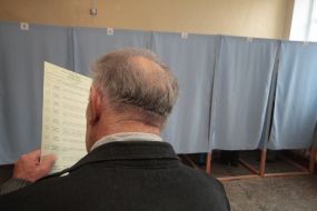 Пожилой мужчина рассматривает избирательный бюллетень