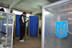 Осужденный рассматривает бюллетень для голосования