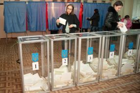 Женщины бросают бюллетени для голосования в урну