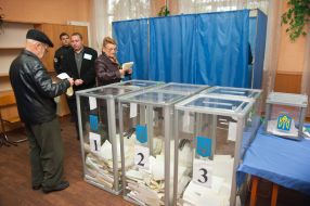 Избиратели рассматривают бюллетени для голосования