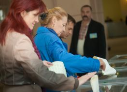 Женщины бросают бюллетени для голосования в урну