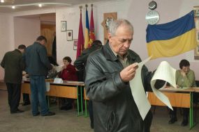 Мужчина рассматривает бюллетени для голосования