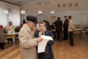 Пожилые люди рассматривают бюллетень для голосования