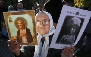 An elderly woman holds an icon