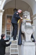 On the sculpture of lion put a mantle on