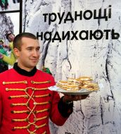 A waiter holding a plate of cakes