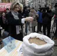 Жінка наповнює колбу зернами пшениці