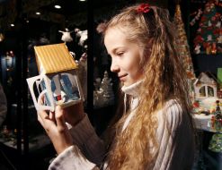 Девочка рассматривает картонный домик