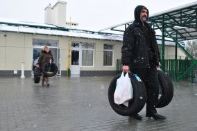 A man carries tires across the border