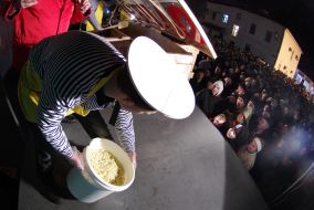 Повар держит ведро с ингредиентами для салата "Оливье"