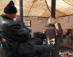A man warms himself near the "stove"