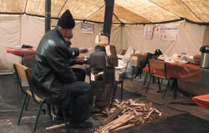 A man warms himself near the "stove"