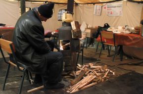 A man warms himself near the "stove"