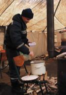 Emergency Ministry employees buckwheat porridge puts in a plastic bowl