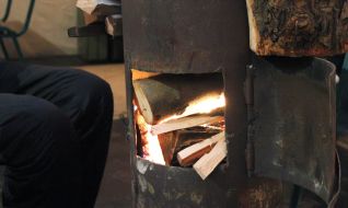 A man warms himself near the "stove"