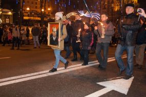 A girl carries a portrait of Stepan Bandera