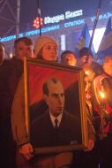 A girl carries a portrait of Stepan Bandera