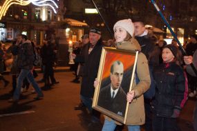 A girl carries a portrait of Stepan Bandera