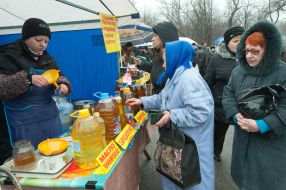 An elderly woman buys sunflower-seed oil