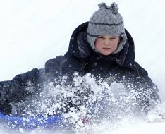 The boy lies in snow