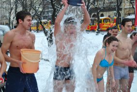 Молодой человек обливается холодной водой 