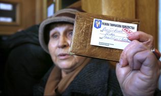 An elderly woman shows a one-time temporary pass