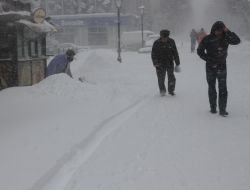 Прохожие идут по заснеженной улице