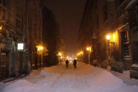 Прохожие идут по заснеженной улице