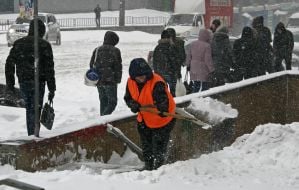 Женщина расчищает лестницу от снега