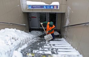 Женщина расчищает лестницу от снега