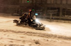 Люди едут на снегоходе