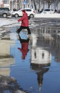 A woman walks on a pedestrian crossing the flooded