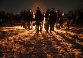 Young people are warm hands by the fire