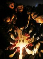 Young people are warm hands by the fire
