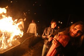 People walk near the fire