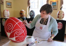 The artist paints pysanka