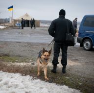 A man holding a German Shepherd on a leash