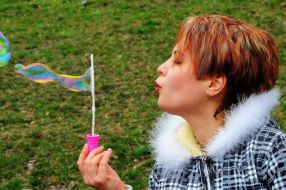 Дівчина пускає мильні бульбашки