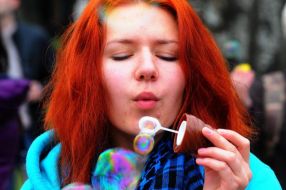 Дівчина пускає мильні бульбашки