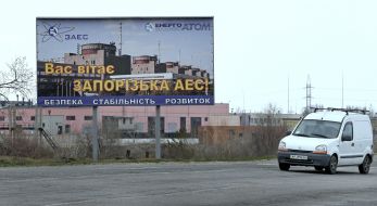 Автомобиль проезжает возле баннера