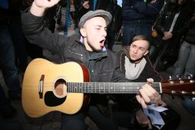 Участник парада гопников играет на гитаре